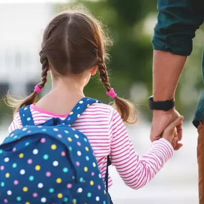 Photo d'une enfant qui tient la main a un adulte